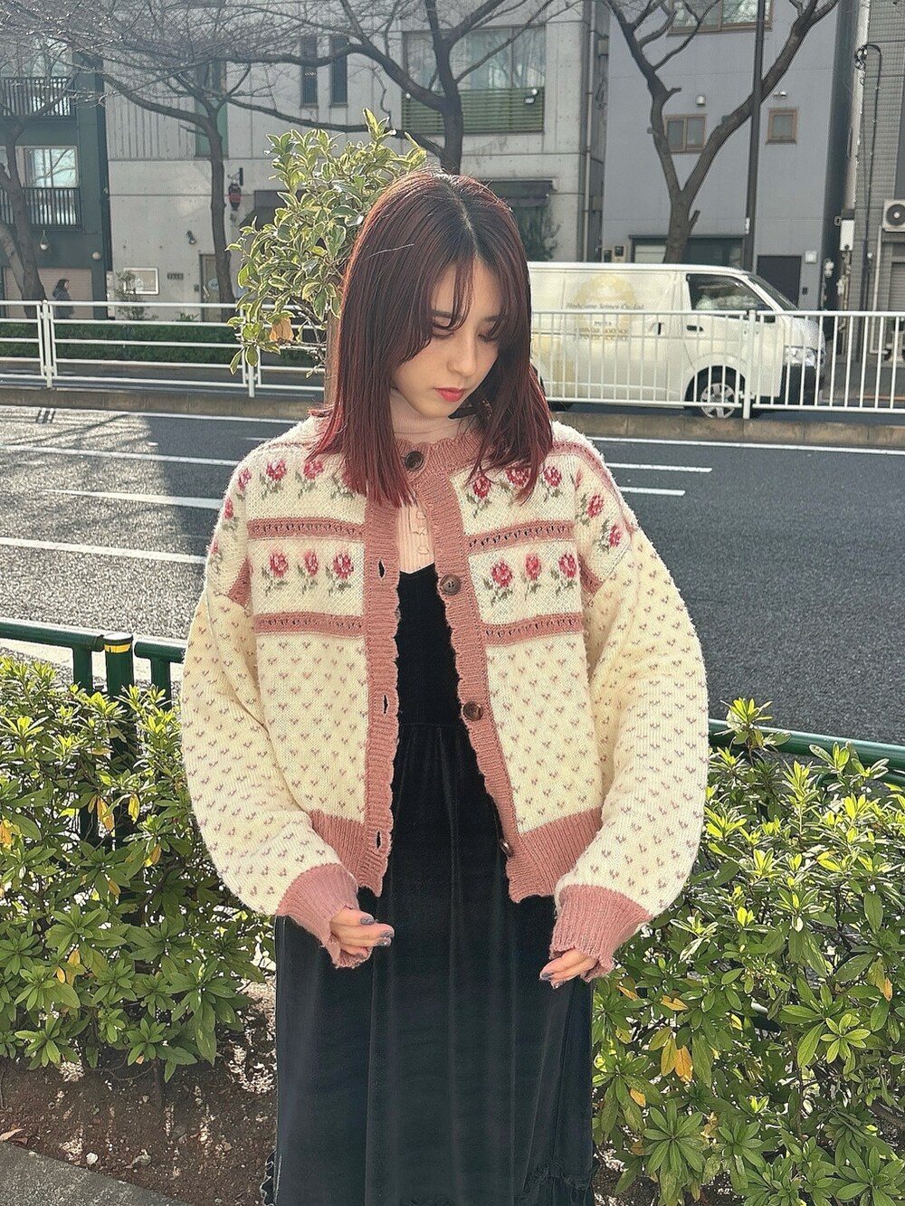 ブラック系のワンピース、ブラック系のスニーカー、ピンク系のカーディガン/ボレロを着用したレディースの冬コーディネートの2枚目の写真