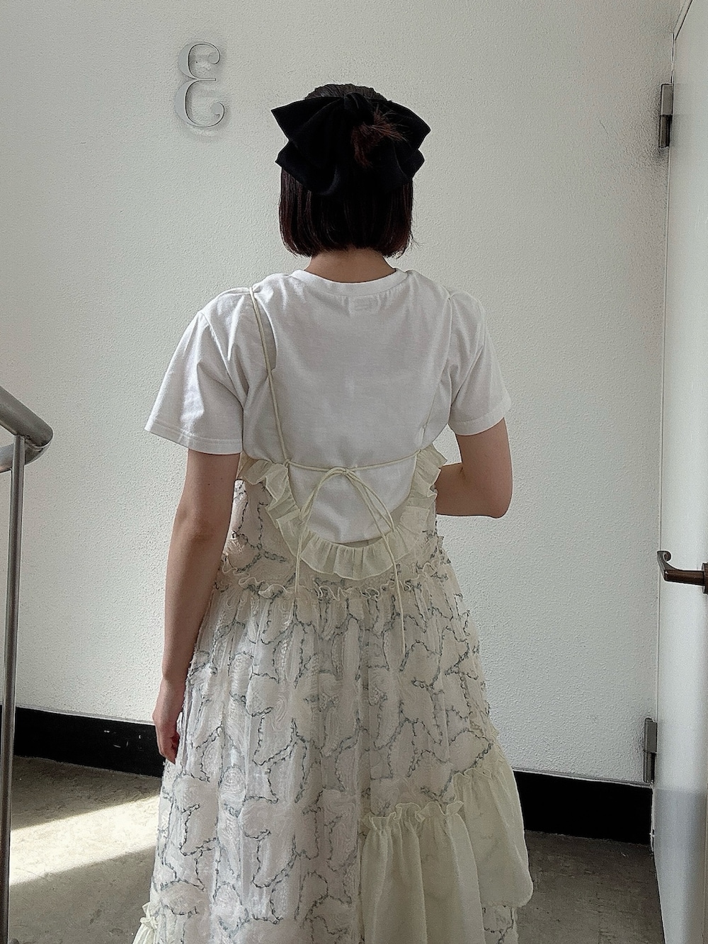 グリーン系のワンピース、ブラウン系のブーツ、ホワイト系のTシャツ/カットソーを着用したレディースの夏コーディネートの4枚目の写真