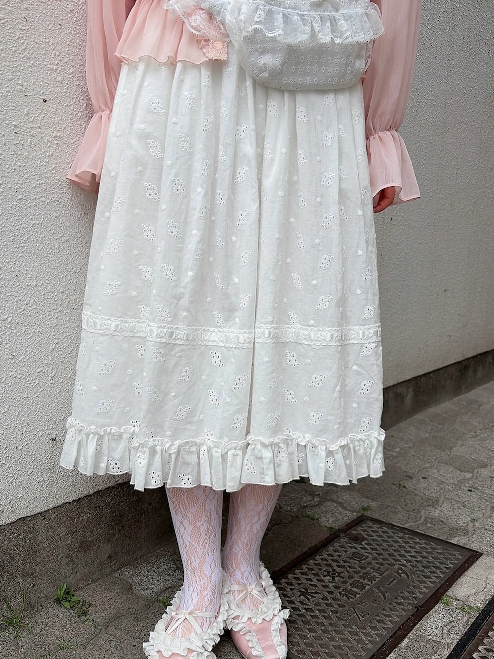 ピンク系のカーディガン/ボレロ、ホワイト系のワンピース、ブラック系のバレエシューズを着用したレディースの春コーディネートの7枚目の写真