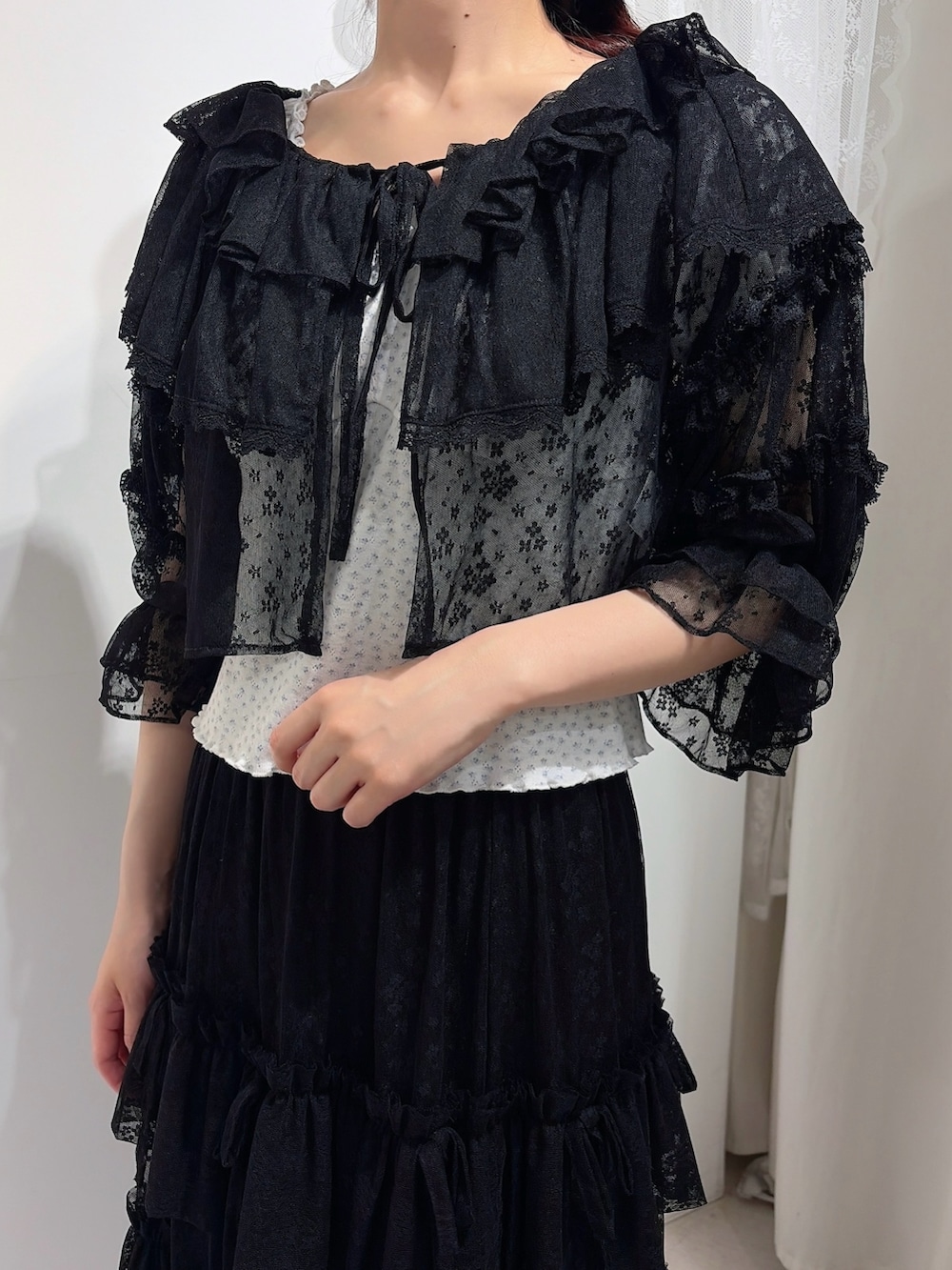 ブラック系のカーディガン/ボレロ、ホワイト系のTシャツ/カットソー、ブラック系のスカートを着用したレディースの春コーディネートの5枚目の写真