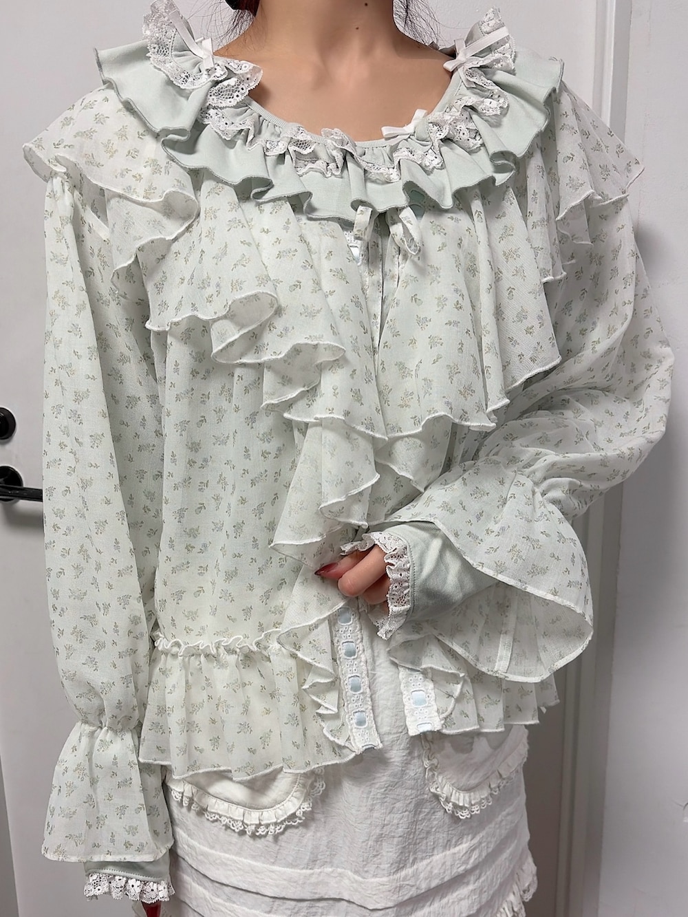 グリーン系のTシャツ/カットソー、ブルー系のカーディガン/ボレロ、ホワイト系のスカートを着用したレディースの冬コーディネートの5枚目の写真