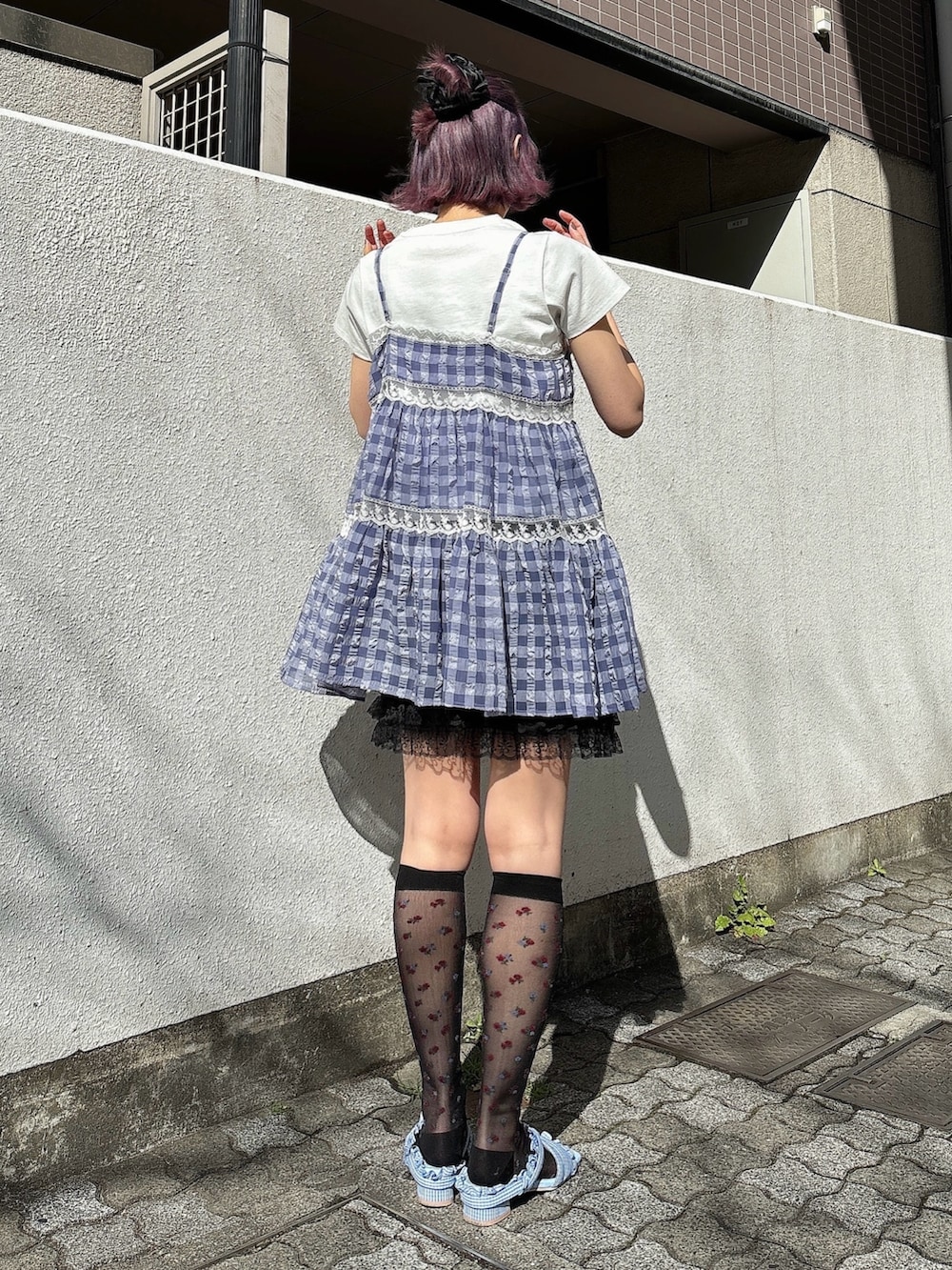 ブルー系のキャミソール、ホワイト系のTシャツ/カットソー、ブラック系のスカートを着用したレディースの春コーディネートの2枚目の写真