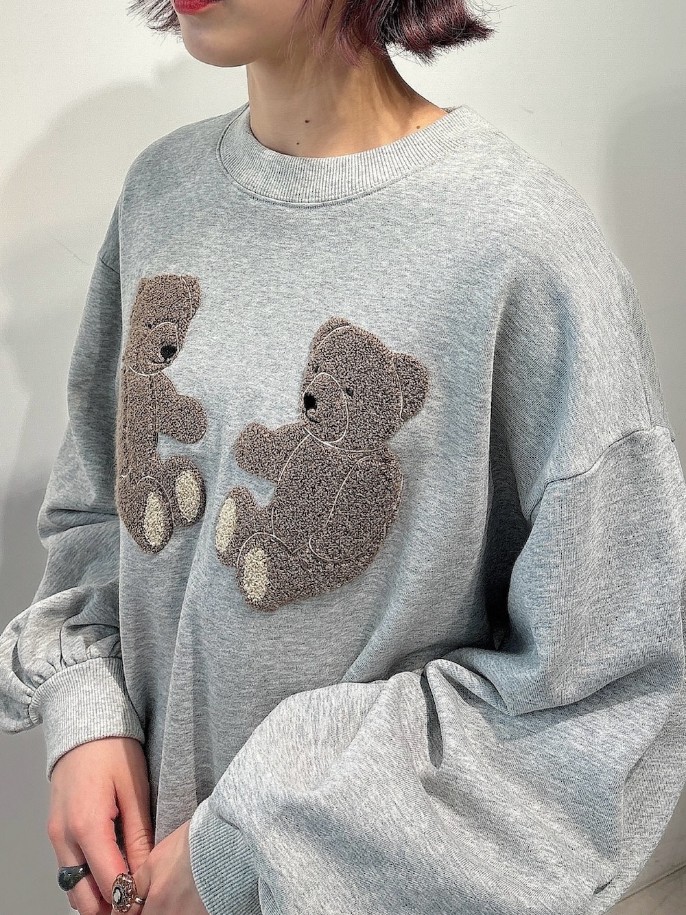 ピンク系のカーディガン/ボレロ、ブラック系のスカート、ブラック系のスニーカーを着用したレディースの冬コーディネートの5枚目の写真