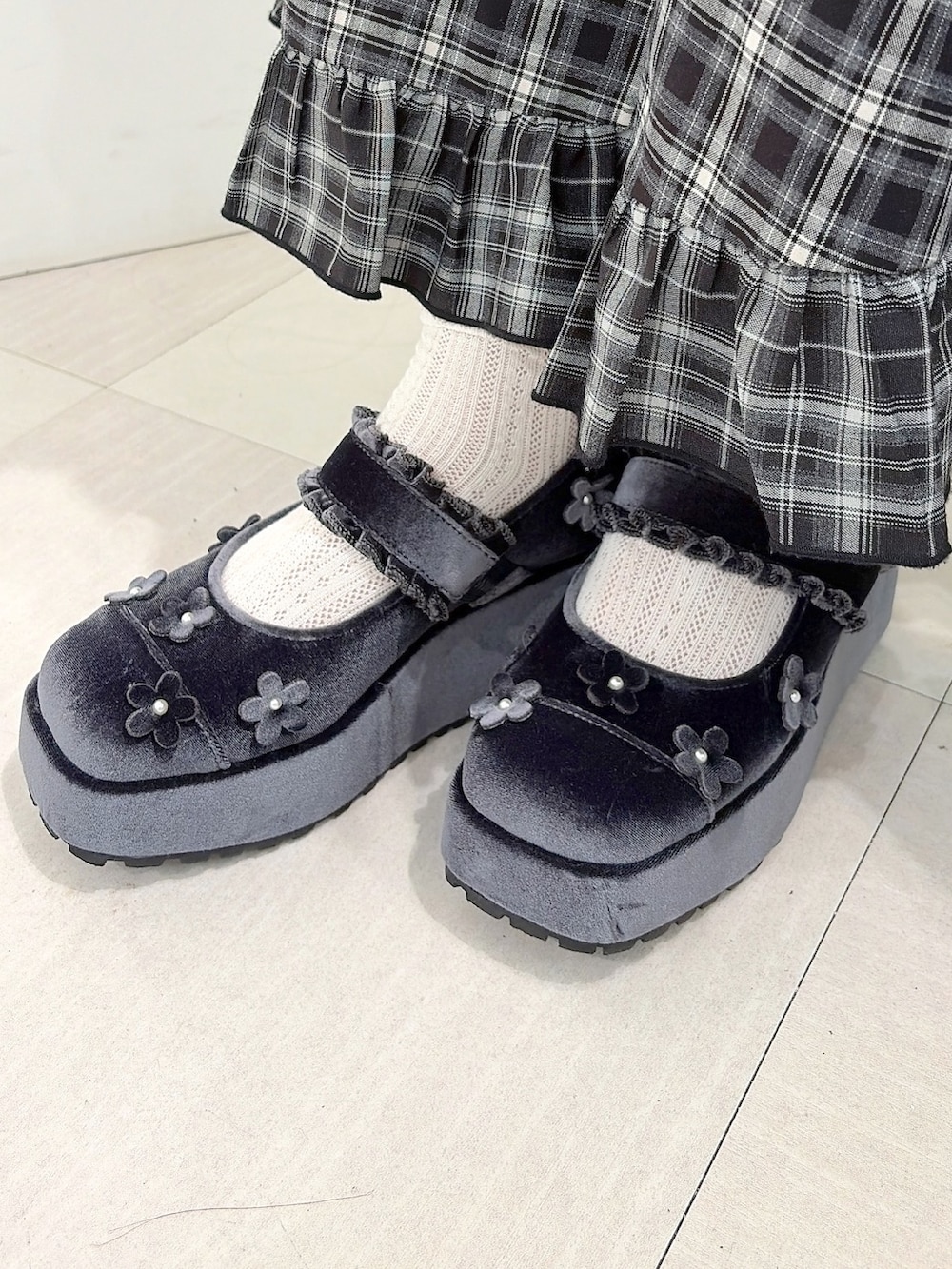 グレー系のニット/セーター、ホワイト系のショルダーバッグ、ブラック系のスカートを着用したレディースの秋コーディネートの9枚目の写真