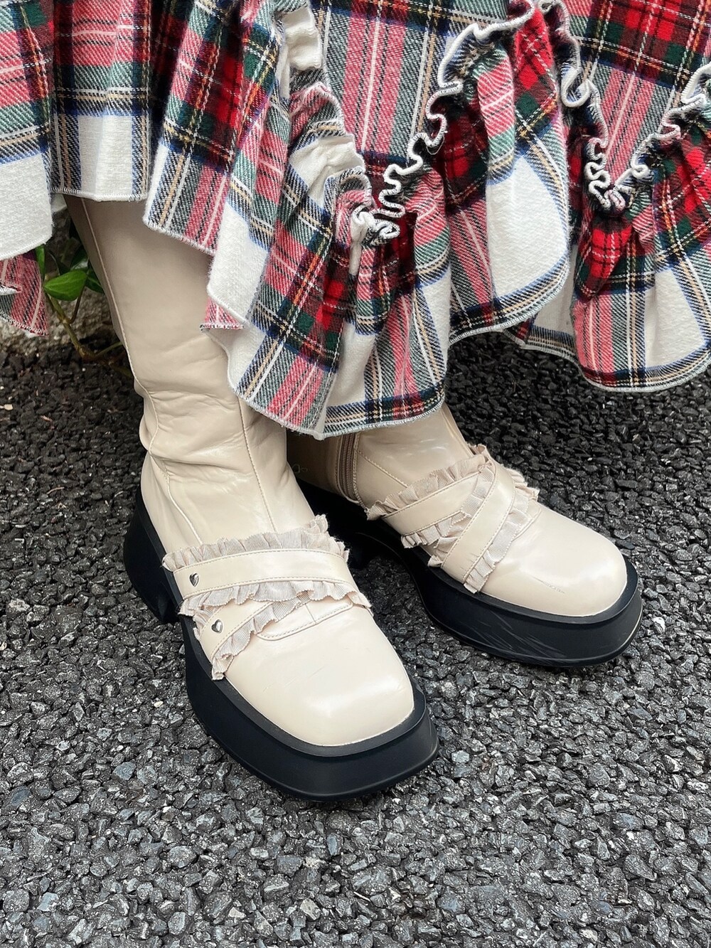 ホワイト系のブーツ、ホワイト系のスカート、レッド系のチェスターコートを着用したレディースの秋コーディネートの5枚目の写真