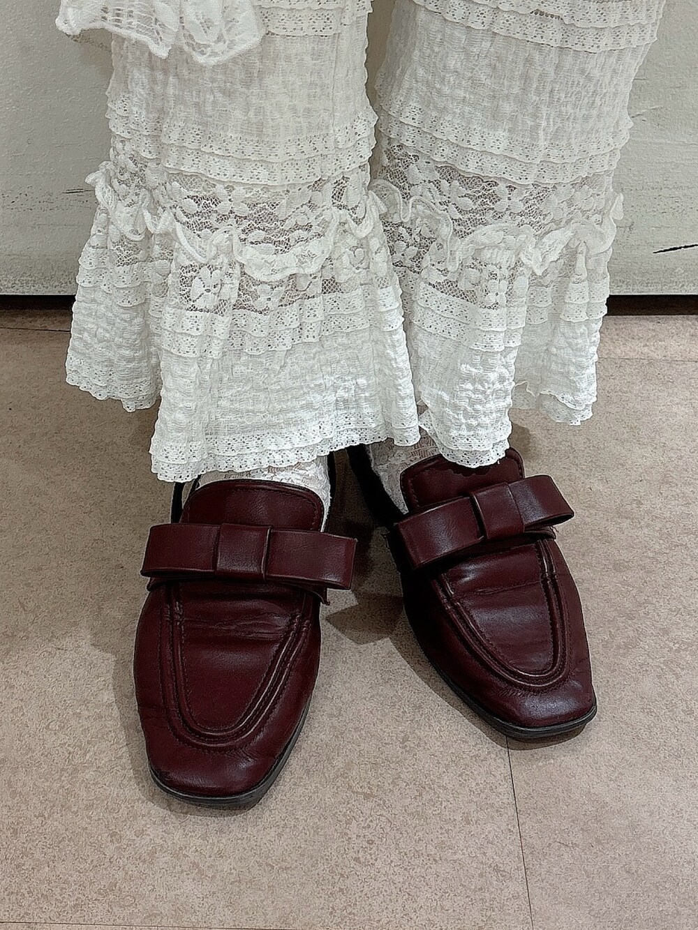 ブラウン系のブルゾン、ブラウン系のニット/セーター、ホワイト系のスカートを着用したレディースの秋コーディネートの7枚目の写真