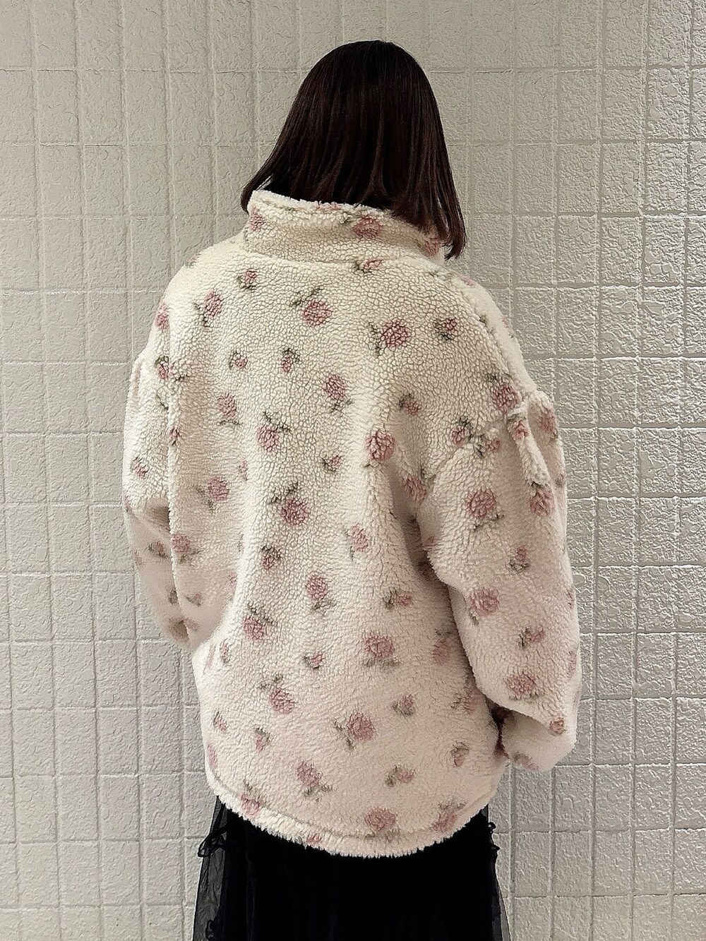 ピンク系のブルゾン、ホワイト系のニット/セーター、ブラック系のスカートを着用したレディースの冬コーディネートの4枚目の写真