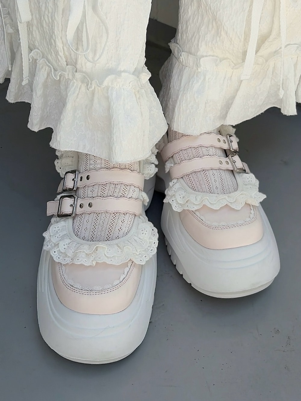グリーン系のワンピース、ホワイト系のカーゴパンツ、ピンク系のスニーカーを着用したレディースの春コーディネートの7枚目の写真