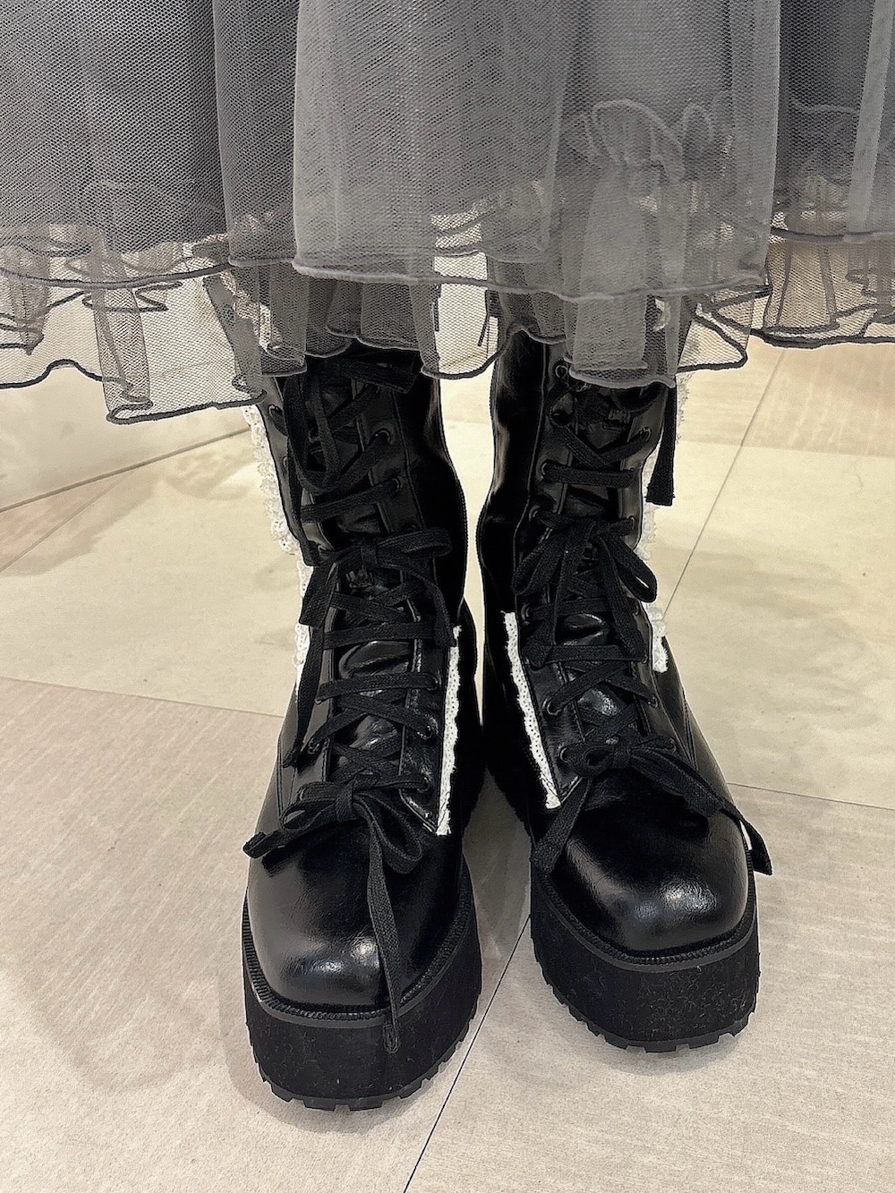 グレー系のワンピース、ホワイト系のシャツ/ブラウス、ブラック系のブーツを着用したレディースの夏コーディネートの6枚目の写真