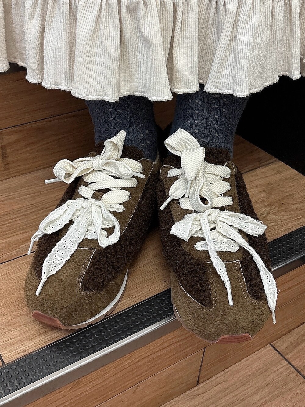 ホワイト系のTシャツ/カットソー、ホワイト系のスカート、ブラウン系のスニーカーを着用したレディースの夏コーディネートの7枚目の写真