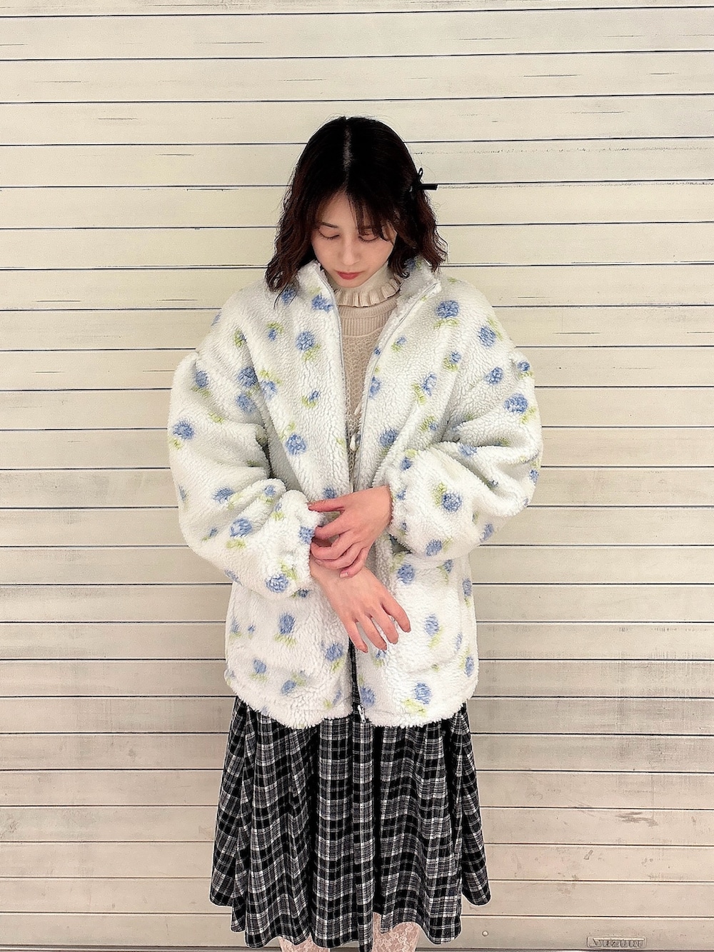 ホワイト系のニット/セーター、ブルー系のブルゾン、ホワイト系のニット/セーターを着用したレディースの冬コーディネートの3枚目の写真