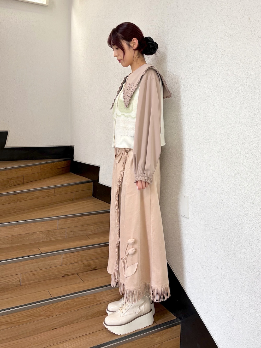 ベージュ系のシャツ/ブラウス、ホワイト系のベスト、ブルー系のハンドバッグを着用したレディースの夏コーディネートの3枚目の写真
