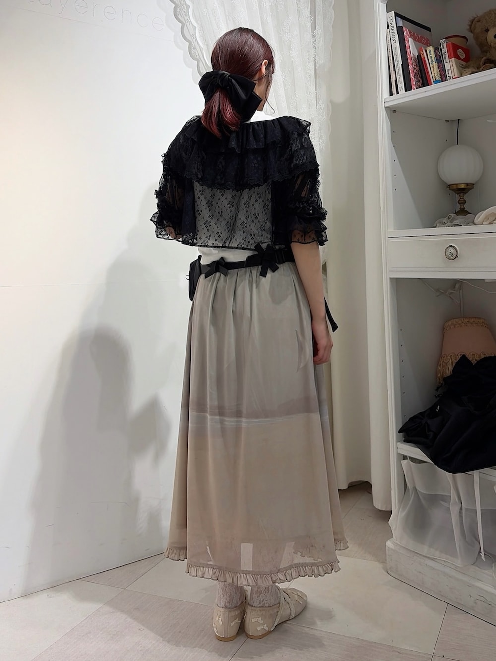 ブラック系のカーディガン/ボレロ、グレー系のスカート、ホワイト系のバレエシューズを着用したレディースの春コーディネートの2枚目の写真