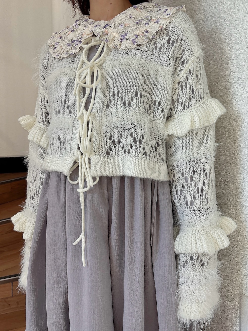 ホワイト系のカーディガン/ボレロ、パープル系のワンピース、ブラック系のパンプスを着用したレディースの秋コーディネートの5枚目の写真