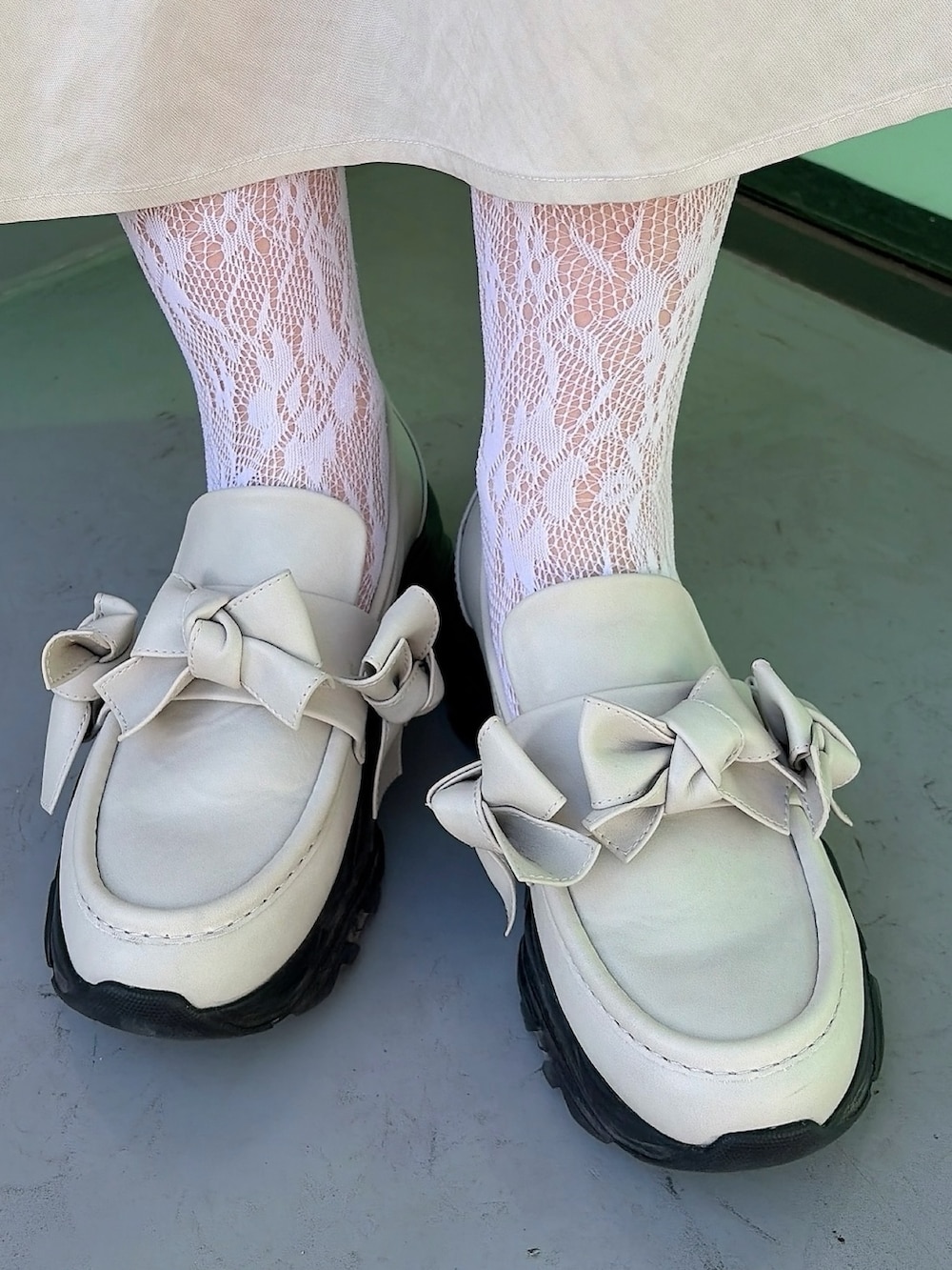 ベージュ系のワンピース、ブラック系のシャツ/ブラウス、ホワイト系のスニーカーを着用したレディースの冬コーディネートの7枚目の写真