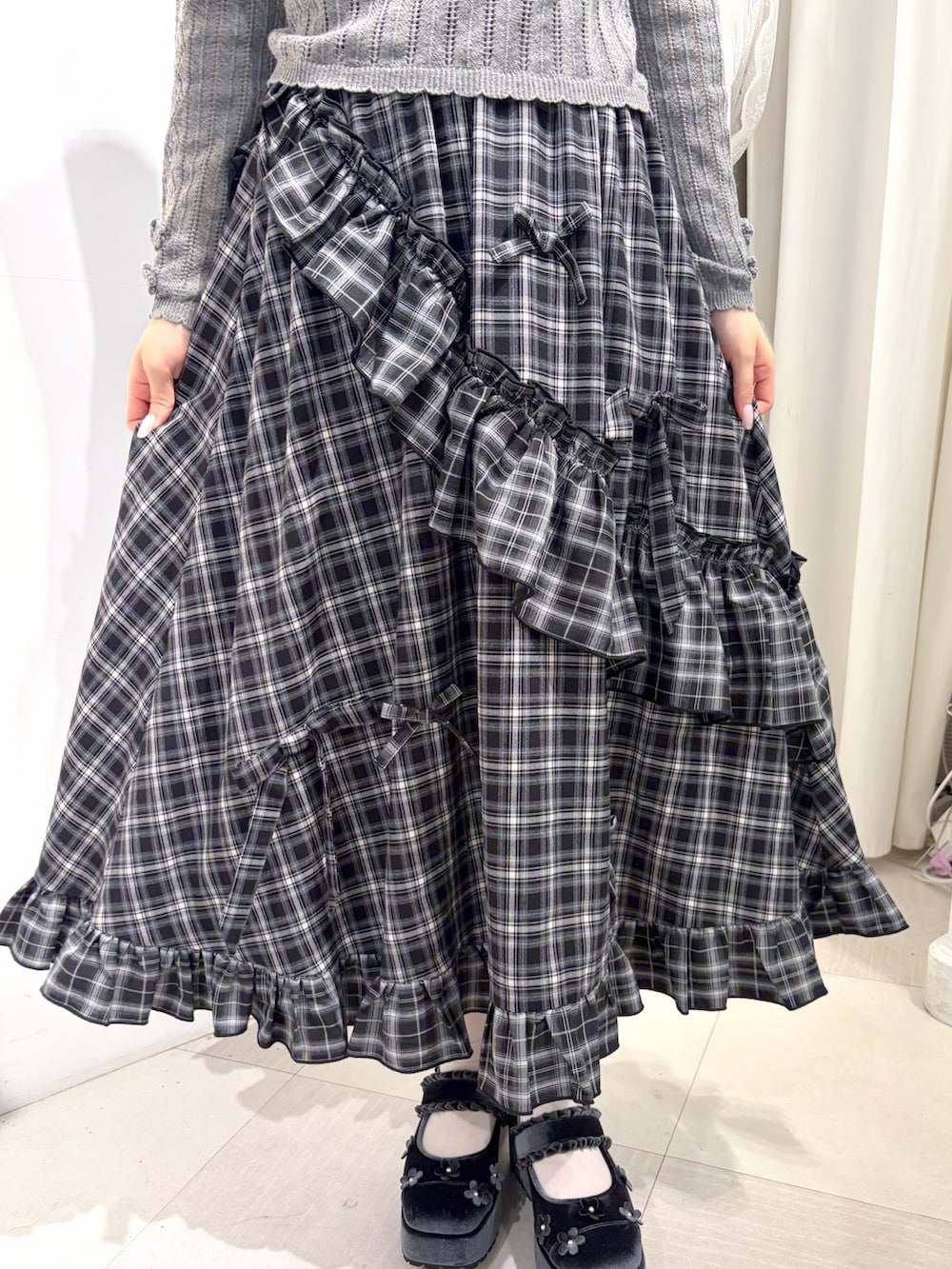 グレー系のニット/セーター、ブラック系のスカート、ブルー系のバレエシューズを着用したレディースの夏コーディネートの7枚目の写真