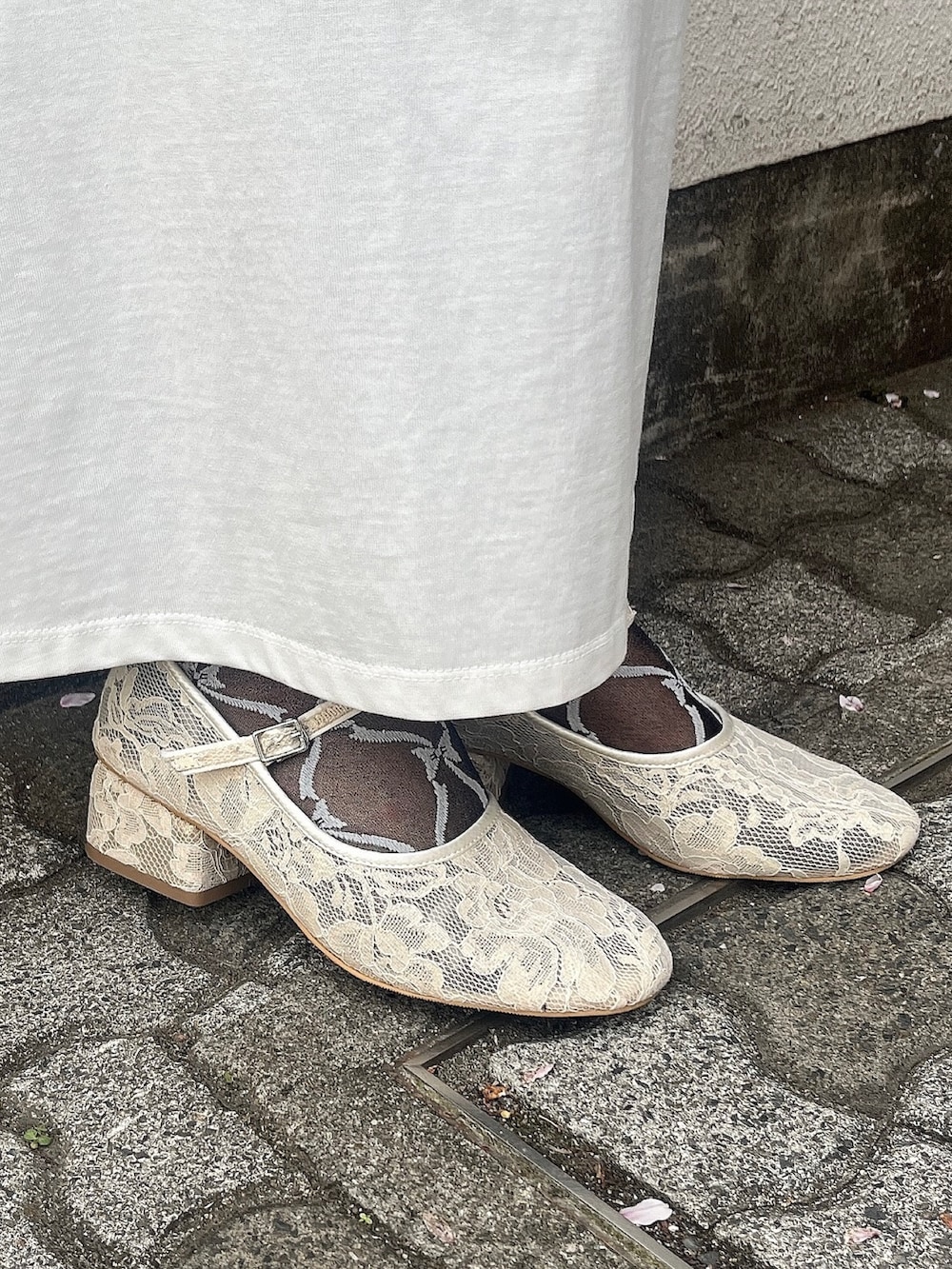 ホワイト系のパンプス、ホワイト系のスカート、ホワイト系のシャツ/ブラウスを着用したレディースの春コーディネートの3枚目の写真