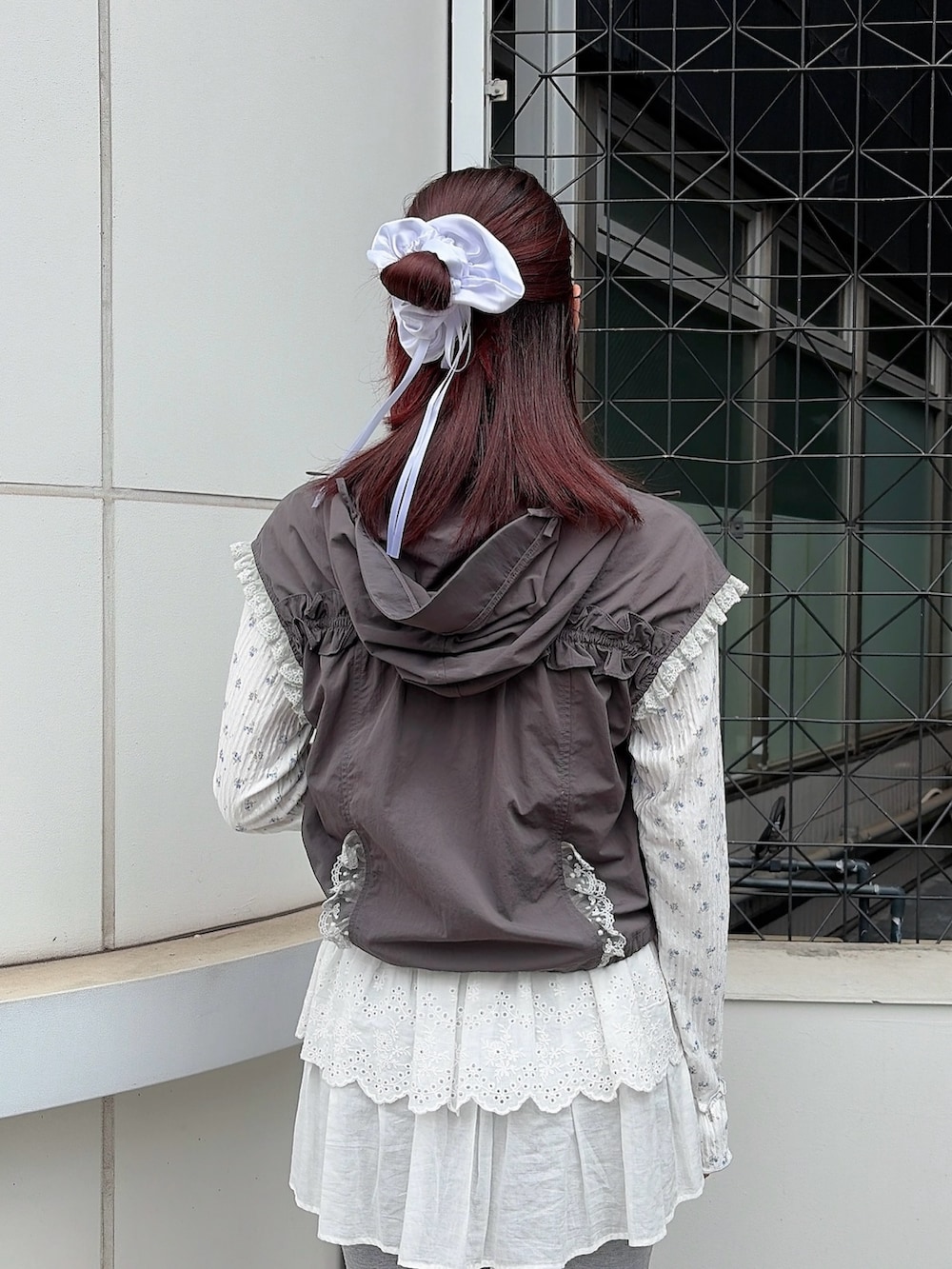 ブルー系のTシャツ/カットソー、グレー系のベスト、ホワイト系のボストンバッグを着用したレディースの春コーディネートの4枚目の写真