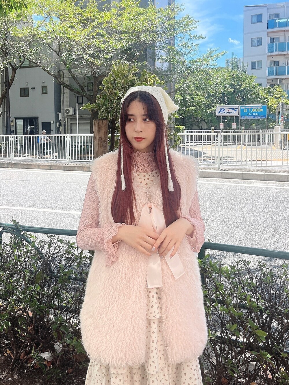 ピンク系のTシャツ/カットソー、ホワイト系のジャンパースカート、ベージュ系のスニーカーを着用したレディースの秋コーディネートの2枚目の写真