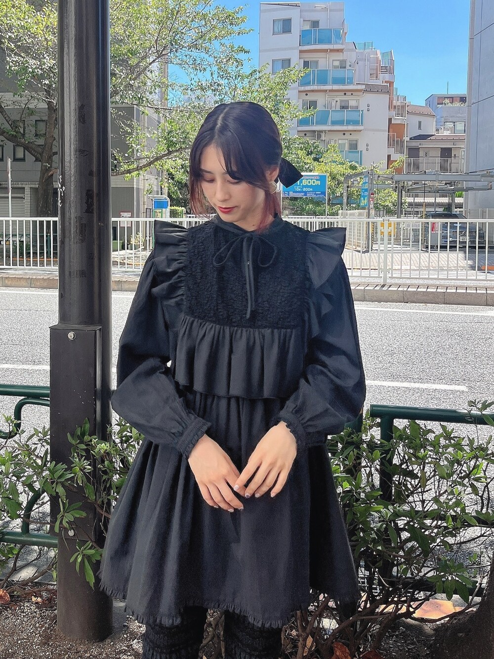 ブラック系のワンピース、ブラック系のスウェットパンツ、ブルー系のスニーカーを着用したレディースの秋コーディネートの2枚目の写真