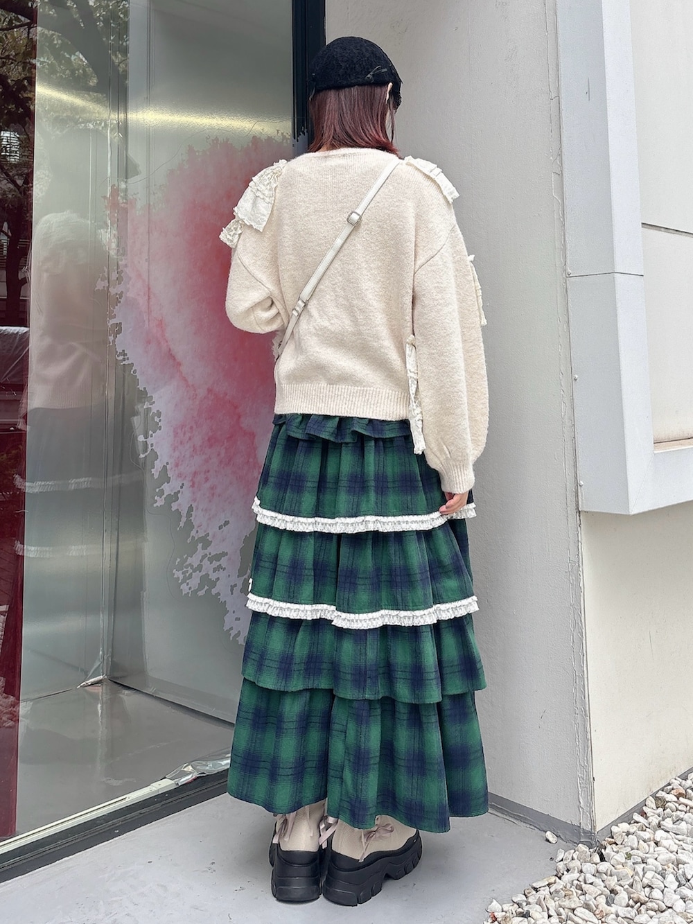 ホワイト系のニット/セーター、ホワイト系のショルダーバッグ、グリーン系のスカートを着用したレディースの秋コーディネートの2枚目の写真