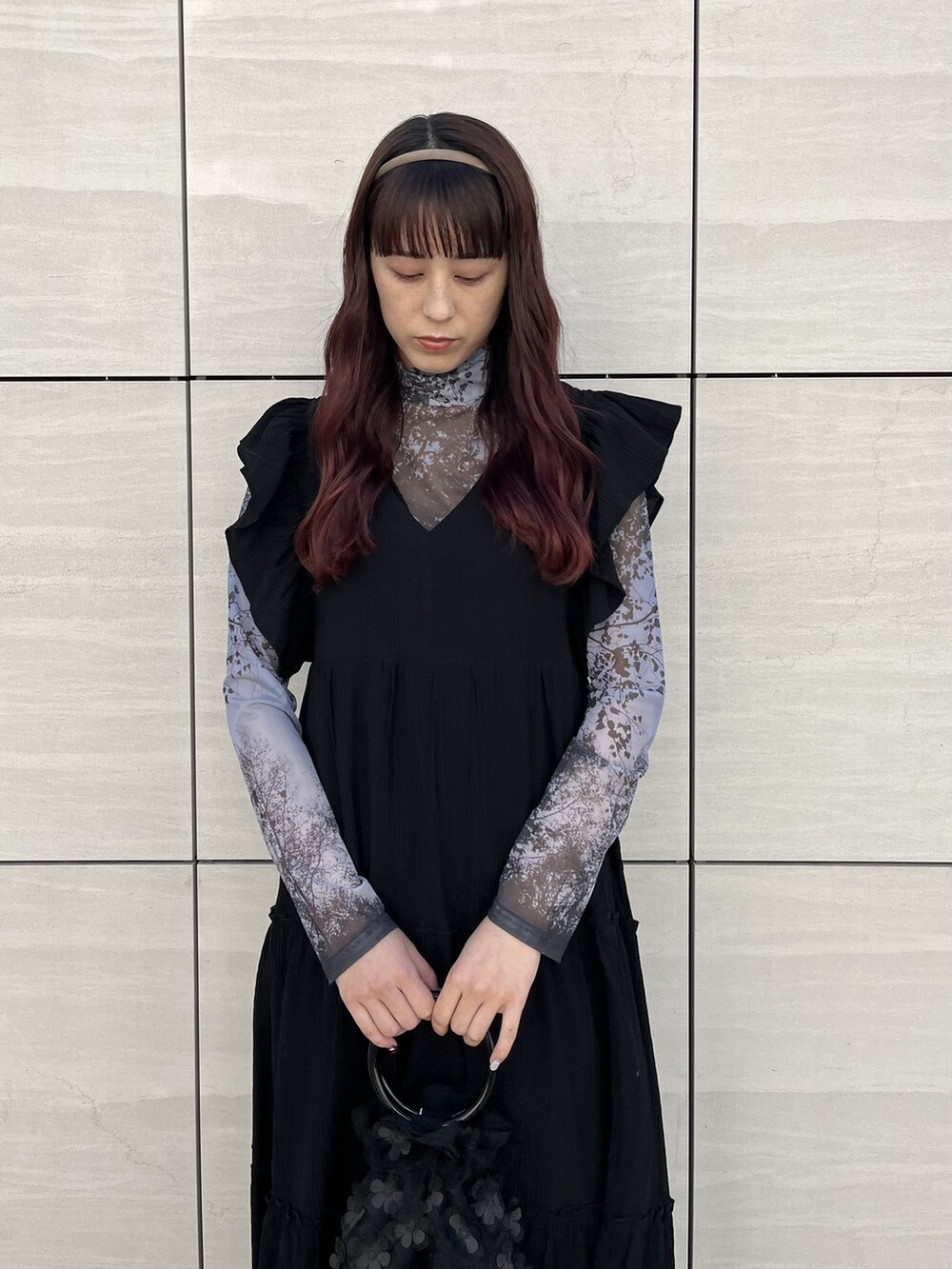 ブラック系のワンピース、ブラック系のパンプス、ブラック系のハンドバッグを着用したレディースの冬コーディネートの2枚目の写真