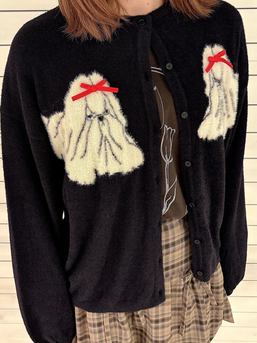 ブラック系のカーディガン/ボレロ、ブラウン系のスカート、ホワイト系のスラックスを着用したレディースの秋コーディネートの5枚目の写真