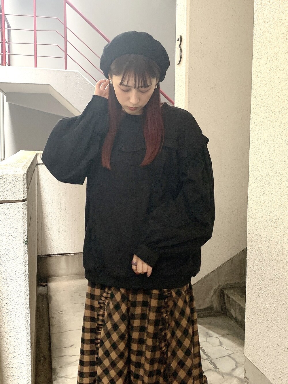 ブラック系のスニーカー、オレンジ系のスカート、ブラック系のスウェットを着用したレディースの秋コーディネートの2枚目の写真