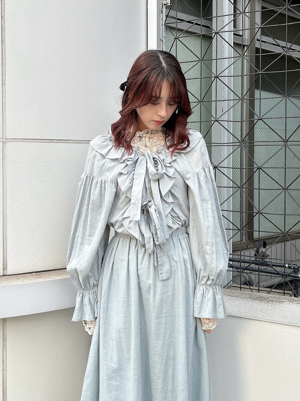 グリーン系のワンピース、ホワイト系のTシャツ/カットソー、ブラック系のパンプスを着用したレディースの冬コーディネートの2枚目の写真