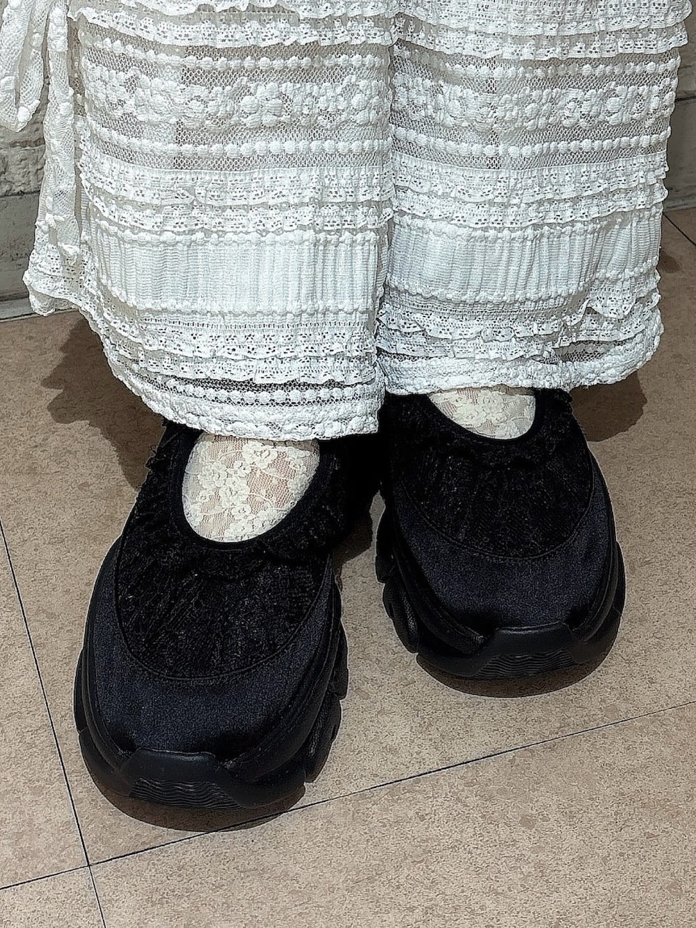 ホワイト系のキャミソール、ホワイト系のその他パンツ、ブラック系のスニーカーを着用したレディースの春コーディネートの6枚目の写真
