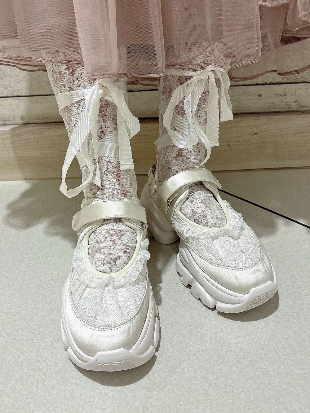 ピンク系のスカート、グレー系のスウェット、ホワイト系のスニーカーを着用したレディースの秋コーディネートの7枚目の写真