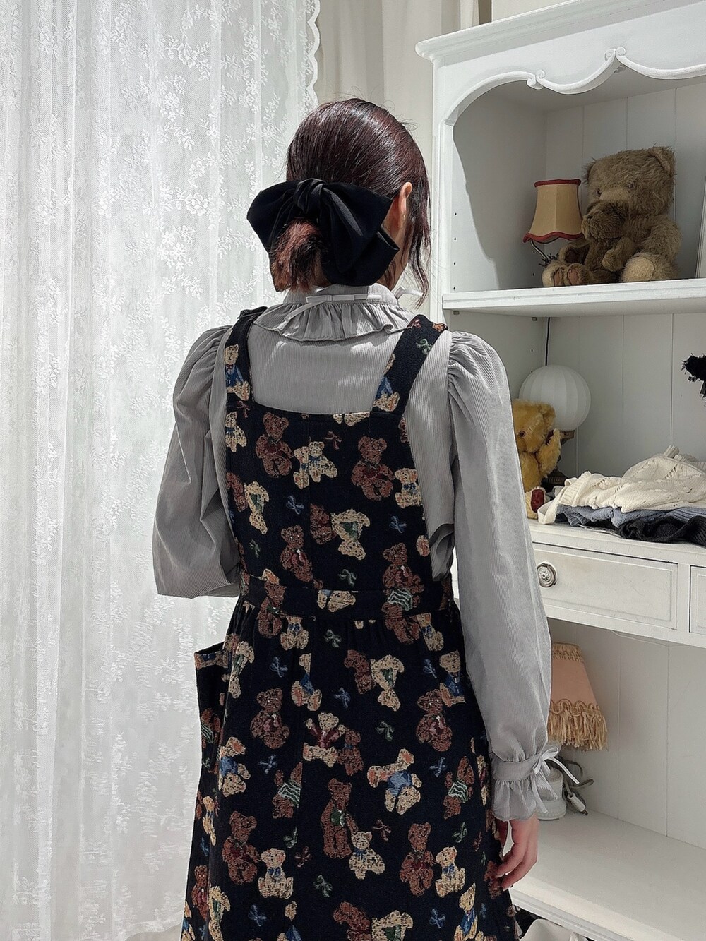 グレー系のシャツ/ブラウス、ブラック系のジャンパースカート、ブラック系のローファーを着用したレディースの秋コーディネートの4枚目の写真