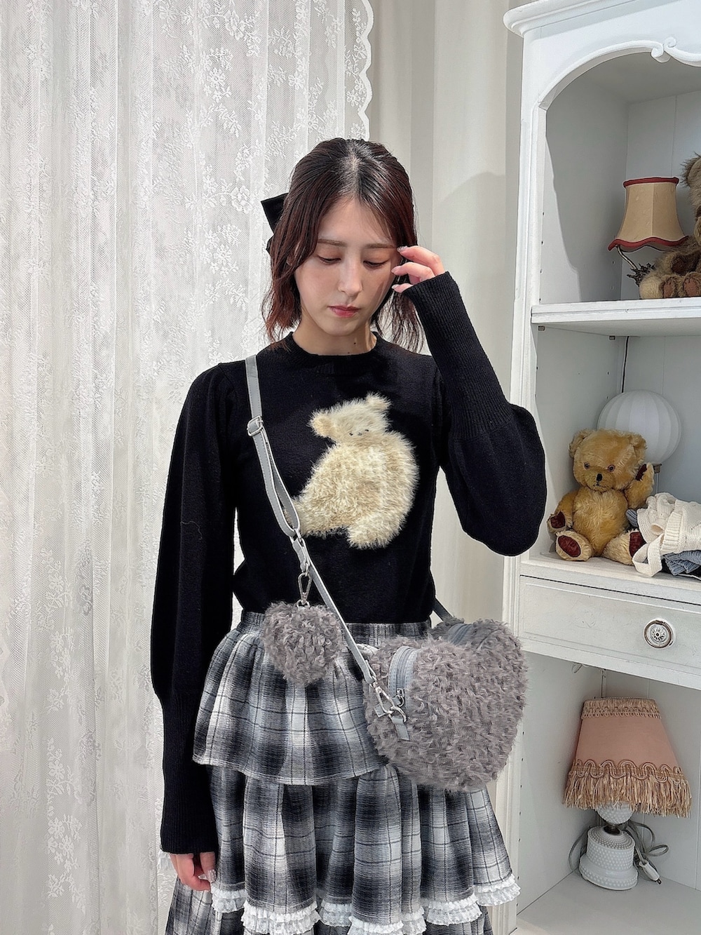 ブラック系のニット/セーター、ブラック系のスカート、グレー系のショルダーバッグを着用したレディースの秋コーディネートの3枚目の写真