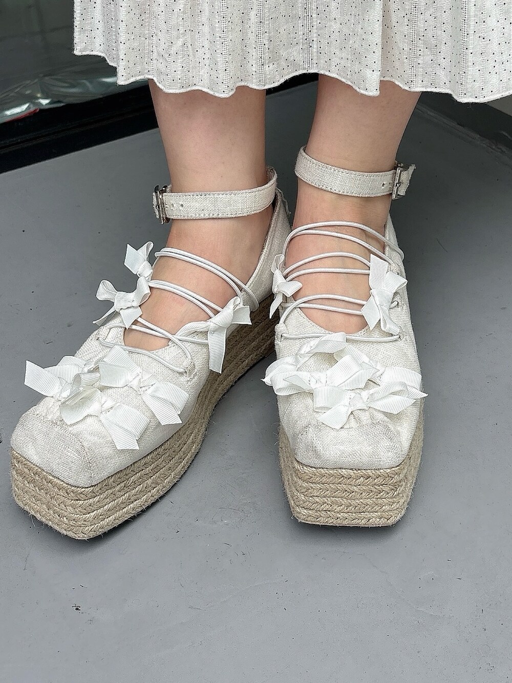 ブルー系のショルダーバッグ、ホワイト系のワンピース、ホワイト系のサンダルを着用したレディースの夏コーディネートの8枚目の写真