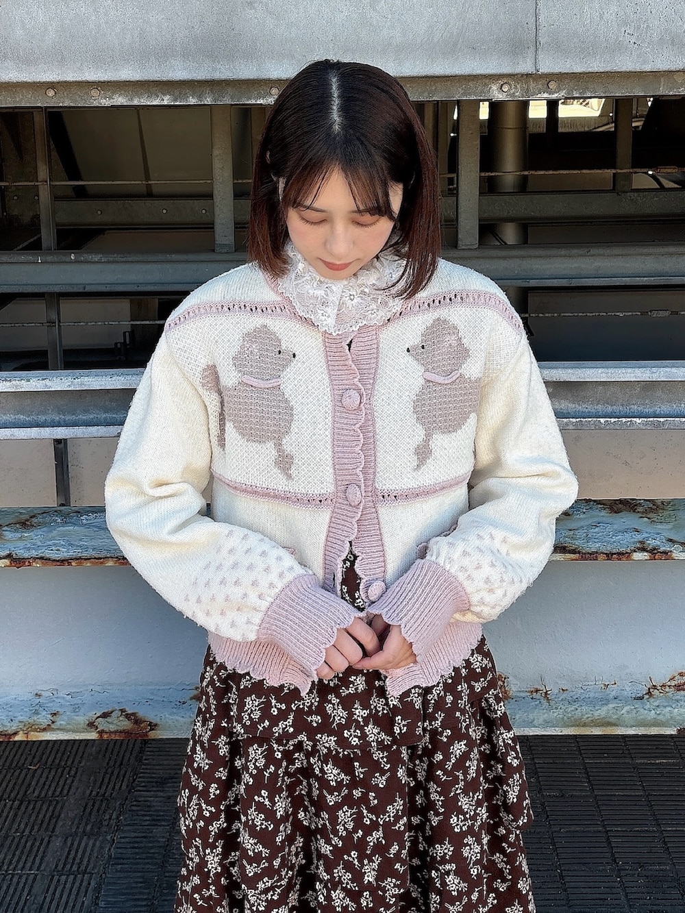 ブラウン系のワンピース、ブラック系のパンプス、ピンク系のカーディガン/ボレロを着用したレディースの冬コーディネートの6枚目の写真