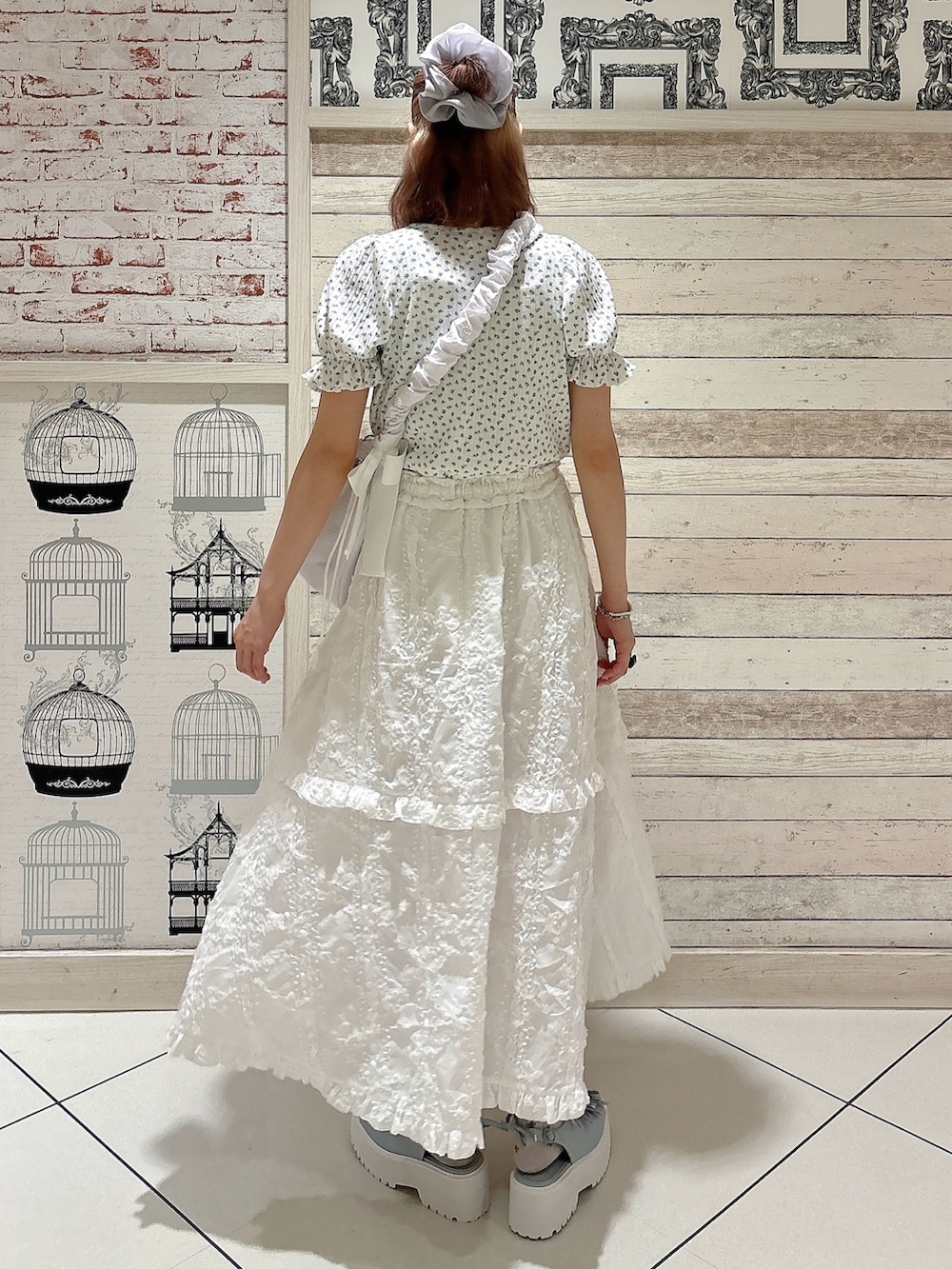 ブルー系のTシャツ/カットソー、ホワイト系のスカート、ブルー系のサンダルを着用したレディースの夏コーディネートの2枚目の写真