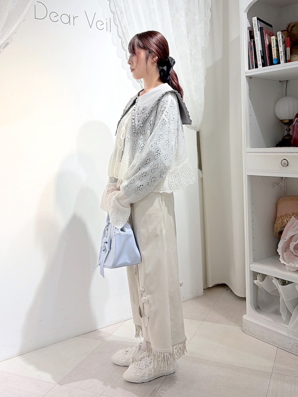 グレー系のシャツ/ブラウス、ホワイト系のカーディガン/ボレロ、ホワイト系のスカートを着用したレディースの秋コーディネートの2枚目の写真