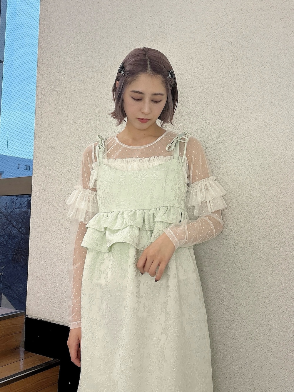 グリーン系のワンピース、ゴールド系のバレエシューズ、ホワイト系のTシャツ/カットソーを着用したレディースの冬コーディネートの2枚目の写真