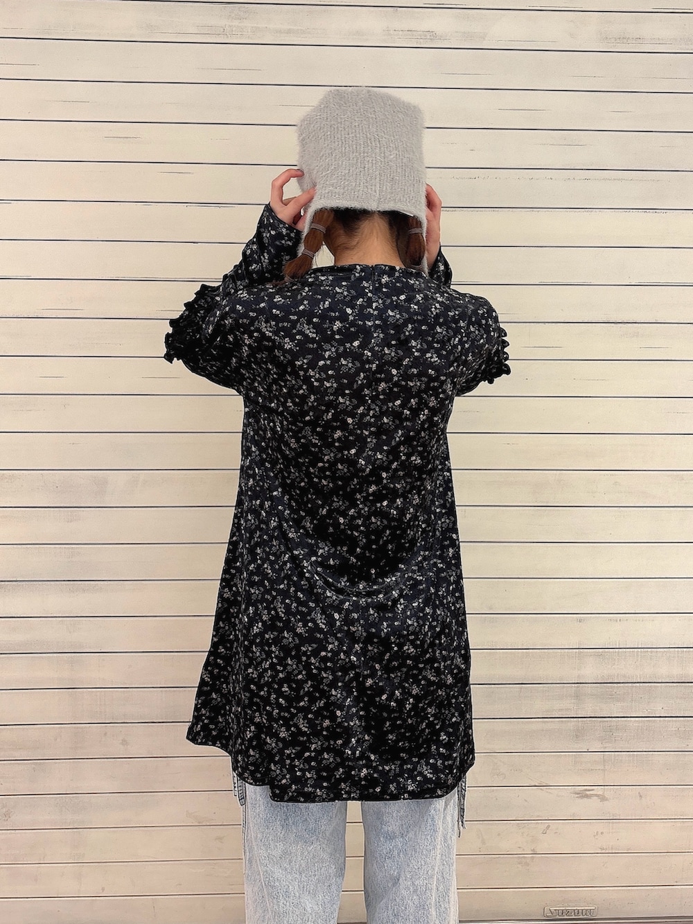 ブラック系のワンピース、ブルー系のデニムパンツ、ブラック系のスニーカーを着用したレディースの秋コーディネートの4枚目の写真