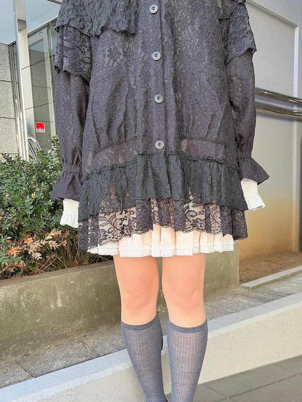 ブラック系のテーラードジャケット、ピンク系のスカート、ブラック系のスニーカーを着用したレディースの冬コーディネートの6枚目の写真