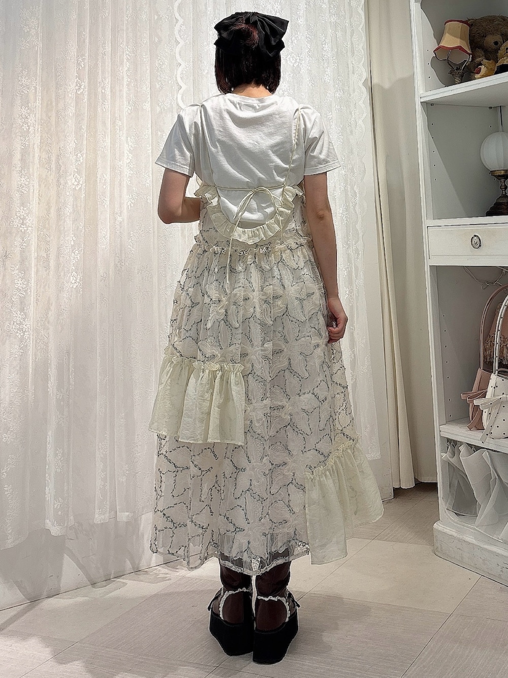 グリーン系のワンピース、ブラウン系のブーツ、ホワイト系のTシャツ/カットソーを着用したレディースの夏コーディネートの2枚目の写真