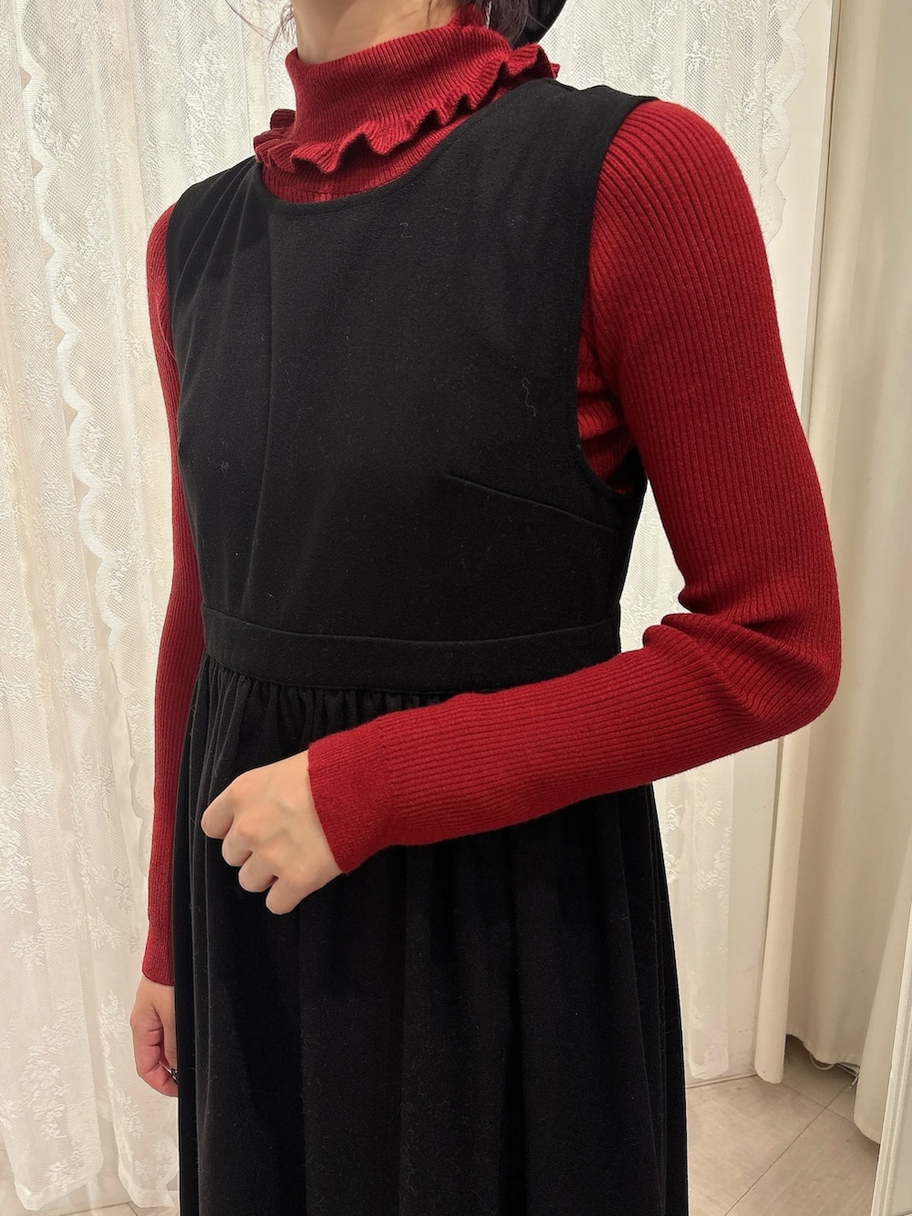 レッド系のニット/セーター、ベージュ系のショルダーバッグ、ブラック系のワンピースを着用したレディースの秋コーディネートの5枚目の写真