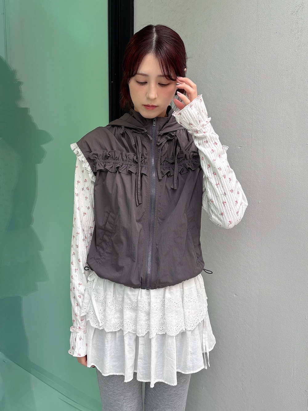 グレー系のベスト、ピンク系のTシャツ/カットソー、グレー系のスウェットパンツを着用したレディースの秋コーディネートの3枚目の写真