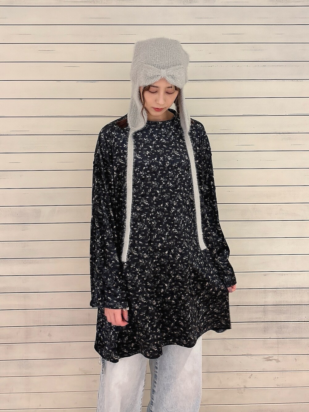 ブラック系のワンピース、ブルー系のデニムパンツ、ブラック系のスニーカーを着用したレディースの秋コーディネートの3枚目の写真