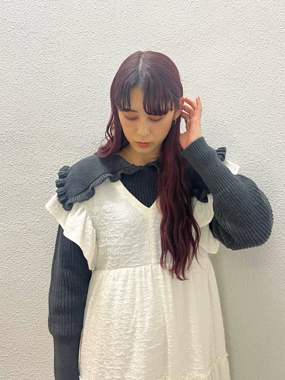 ホワイト系のワンピース、グレー系のニット/セーター、ブラック系のパンプスを着用したレディースの冬コーディネートの2枚目の写真