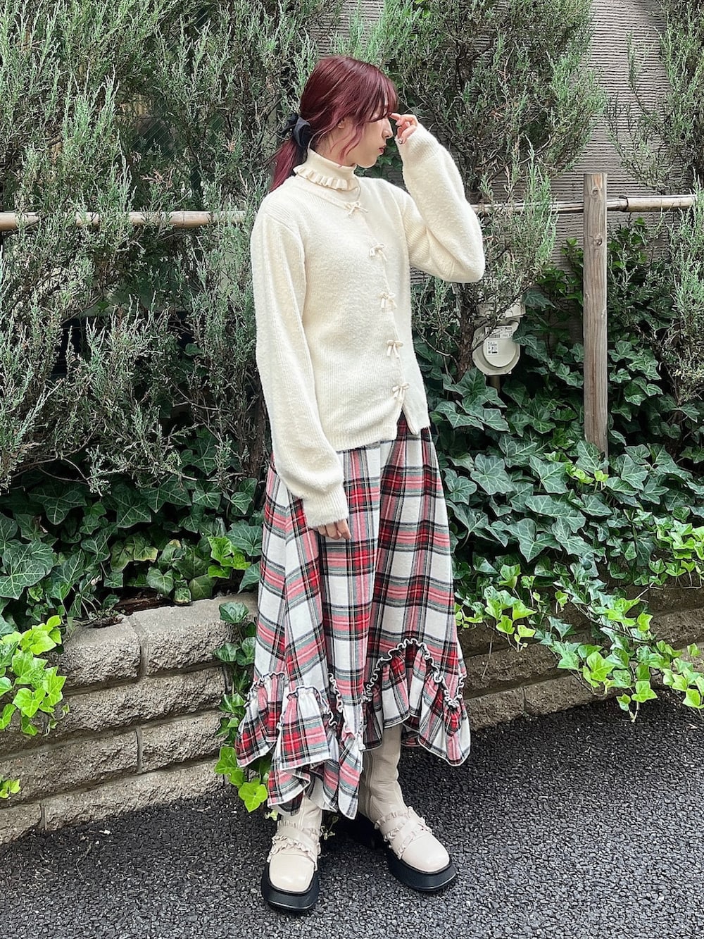 ホワイト系のブーツ、ホワイト系のスカート、レッド系のチェスターコートを着用したレディースの秋コーディネートの3枚目の写真