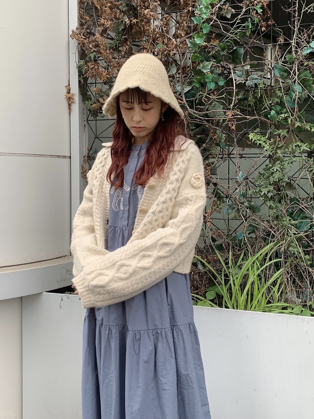 ブルー系のワンピース、ホワイト系のカーディガン/ボレロ、ホワイト系のハットを着用したレディースの秋コーディネートの2枚目の写真