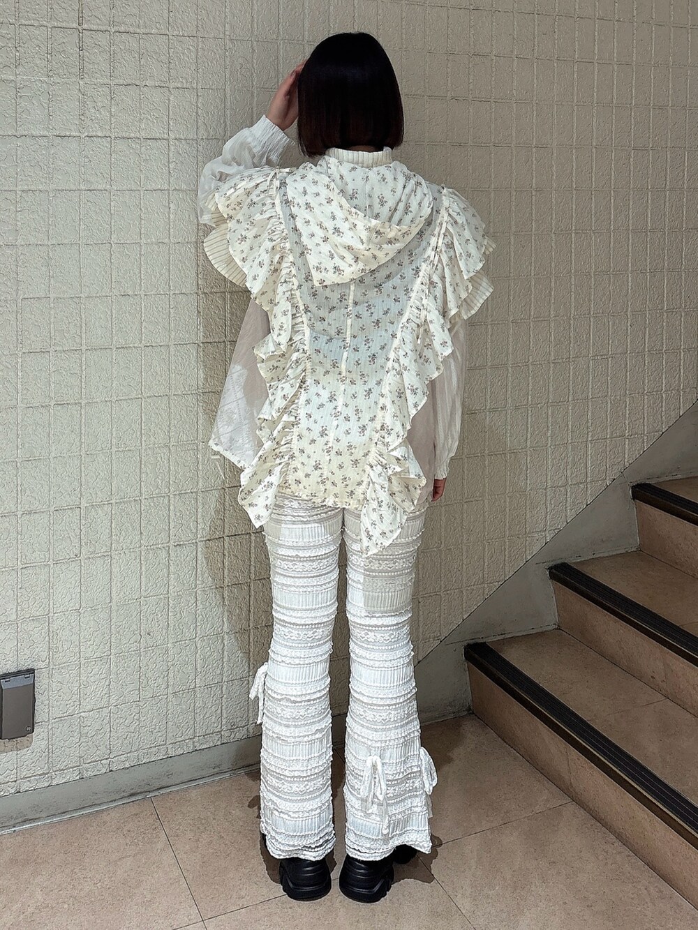 ピンク系のブルゾン、ホワイト系のその他パンツ、ブラック系のスニーカーを着用したレディースの春コーディネートの2枚目の写真