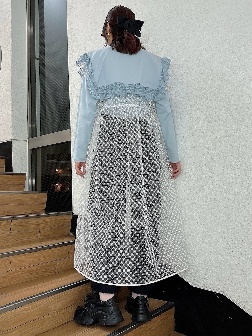 ホワイト系のワンピース、ブラック系のカーゴパンツ、ブラック系のスニーカーを着用したレディースの冬コーディネートの2枚目の写真