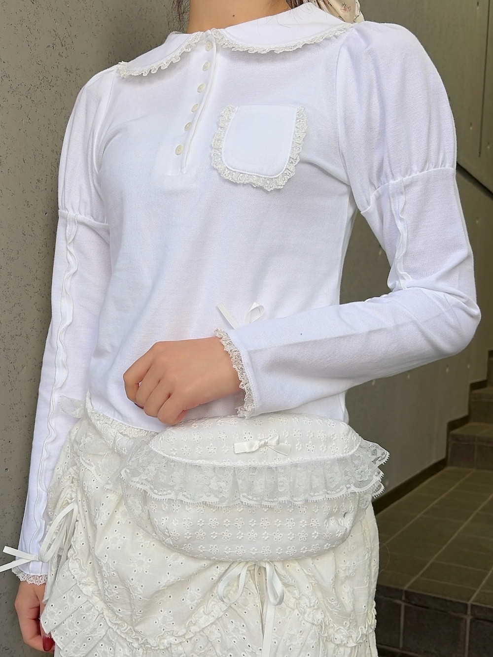 ホワイト系のポロシャツ、ホワイト系のボディバッグ/ウエストポーチ、ホワイト系のスカートを着用したレディースの冬コーディネートの5枚目の写真